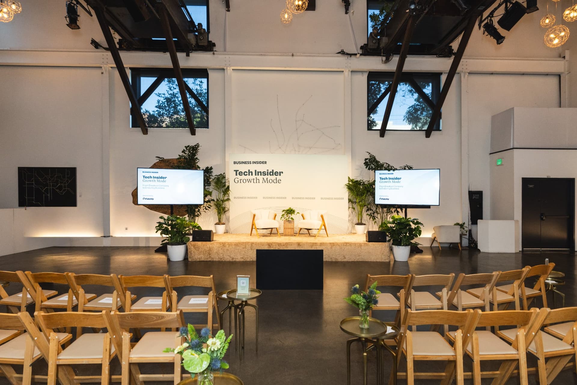Rows of wooden chairs facing the Tech Insider stage before the event at Business Insider Tech Insider: Growth Mode at The Pearl SF during SF Tech Week 2026 in San Francisco by JY Studio