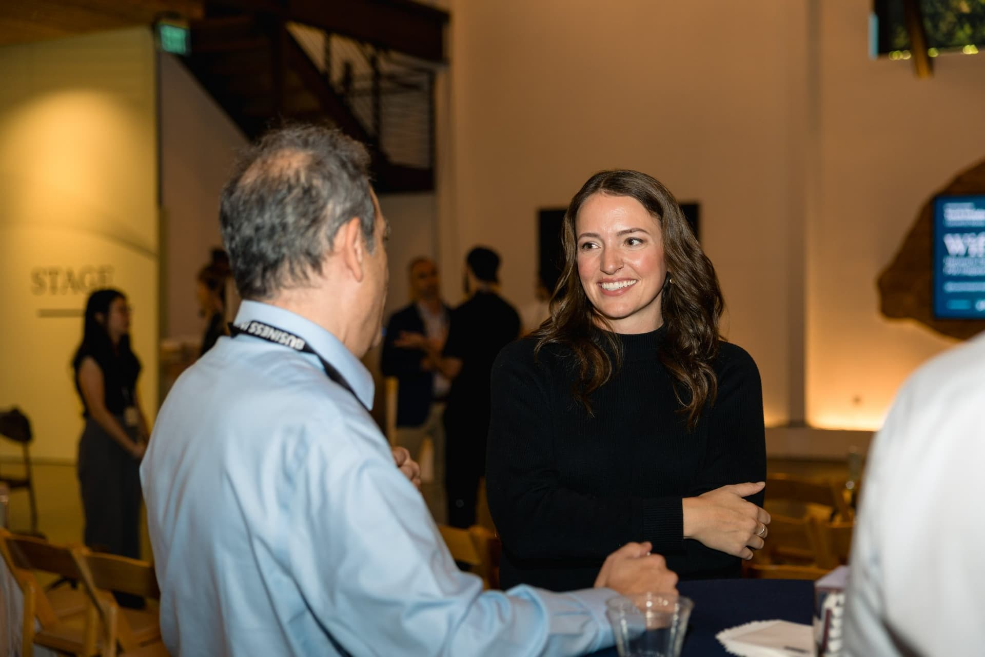 Attendee smiling in conversation during the reception at Business Insider Tech Insider: Growth Mode at The Pearl SF during SF Tech Week 2026 in San Francisco by JY Studio
