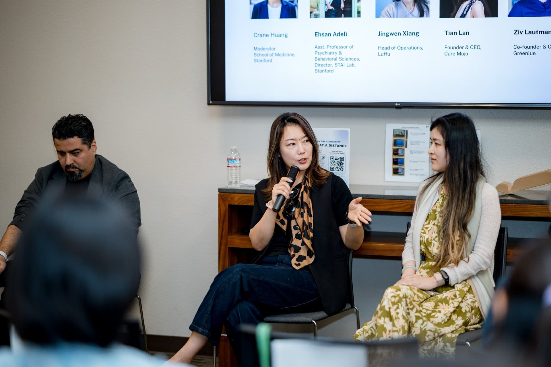 Panelist gesturing while answering a question during Panel 1 "Sensing Wellbeing from a Distance" at Care at a Distance: AI, Sensors, Robotics and the Future of Aging, SF Tech Week 2026 at EVGR, Stanford University by JY Studio