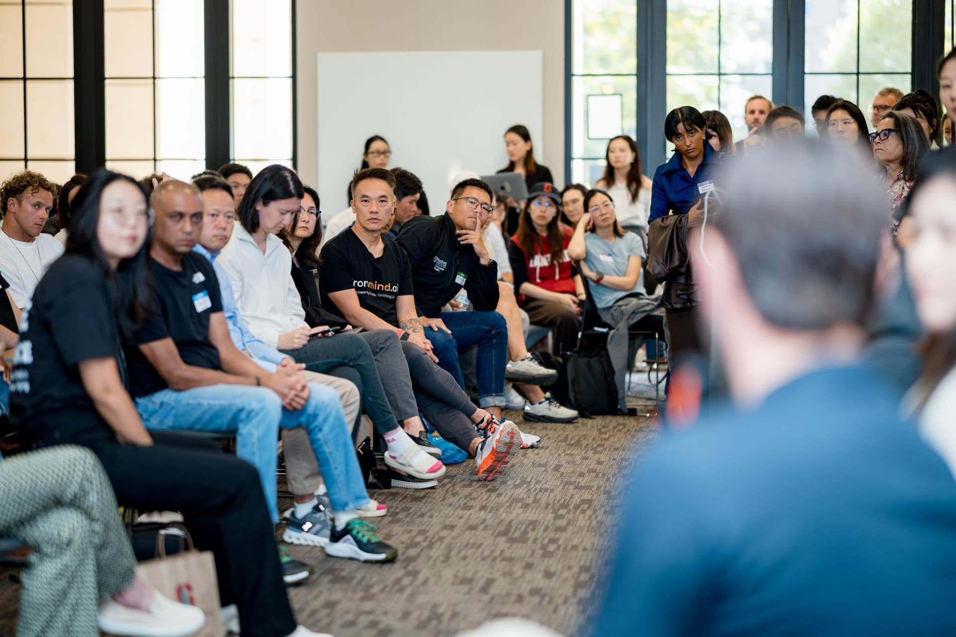 Wide view of attendees listening as an audience member speaks at Care at a Distance: AI, Sensors, Robotics and the Future of Aging, SF Tech Week 2026 at EVGR, Stanford University by JY Studio