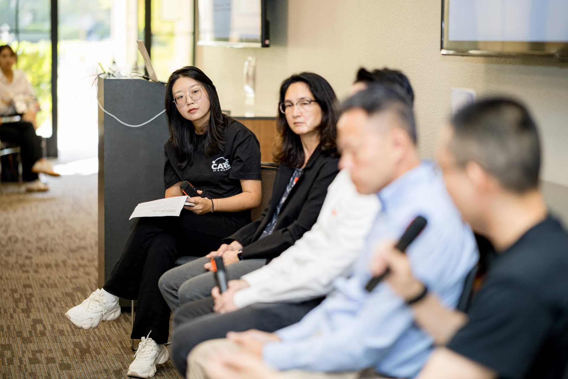 Row of moderator and panelists listening during Panel 2 "Robotics for Independent Living" at Care at a Distance: AI, Sensors, Robotics and the Future of Aging, SF Tech Week 2026 at EVGR, Stanford University by JY Studio