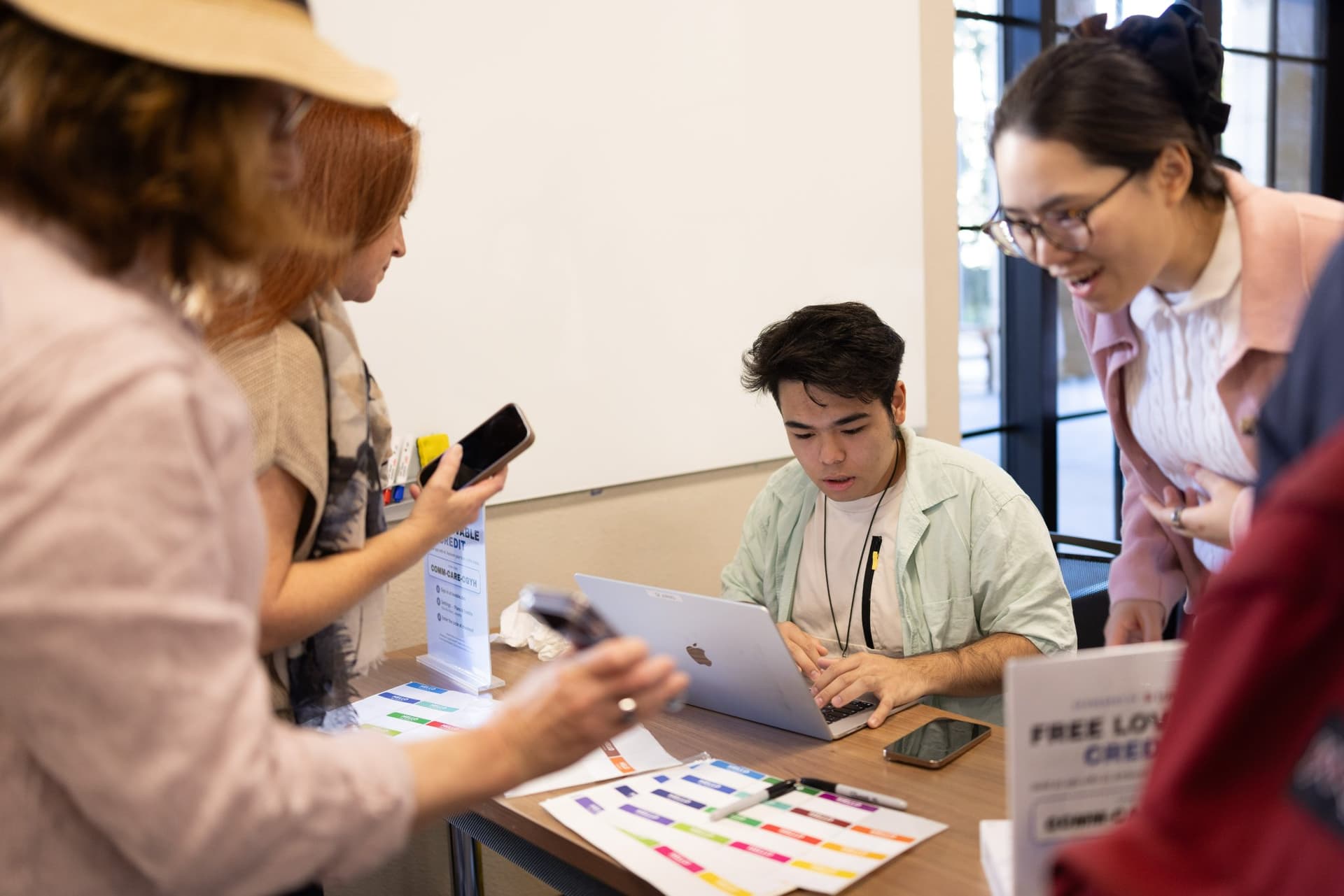 Guests checking in at the registration table and writing name tags at Care at a Distance: AI, Sensors, Robotics and the Future of Aging, SF Tech Week 2026 at EVGR, Stanford University by JY Studio