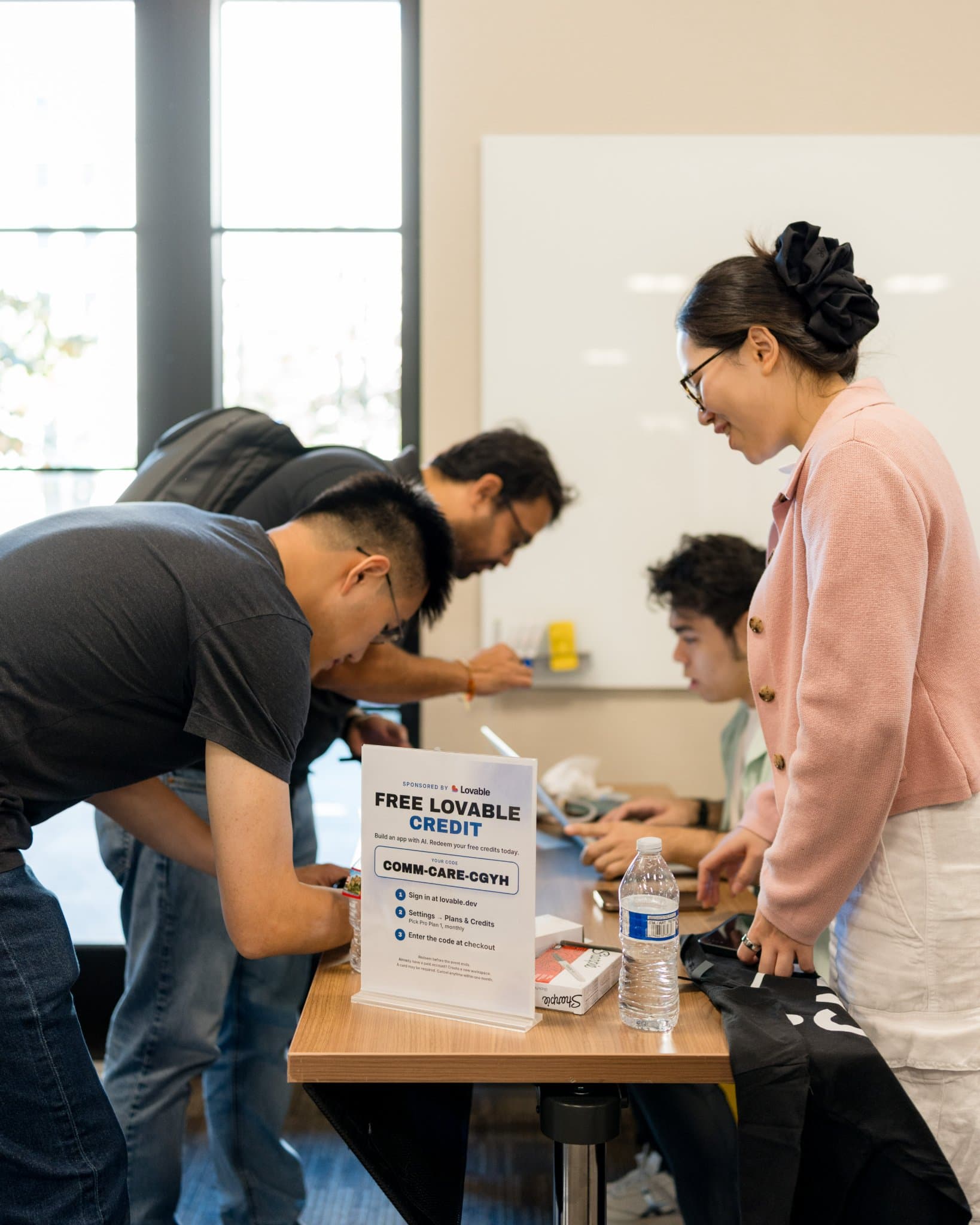 Vertical shot of guests checking in beside the Free Lovable Credit sign at Care at a Distance: AI, Sensors, Robotics and the Future of Aging, SF Tech Week 2026 at EVGR, Stanford University by JY Studio