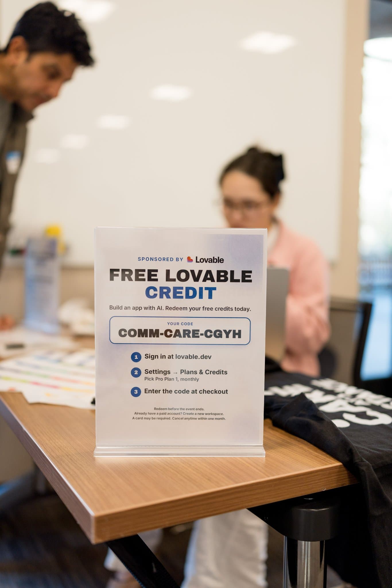 Vertical shot of the Lovable-sponsored Free Lovable Credit sign at check-in at Care at a Distance: AI, Sensors, Robotics and the Future of Aging, SF Tech Week 2026 at EVGR, Stanford University by JY Studio