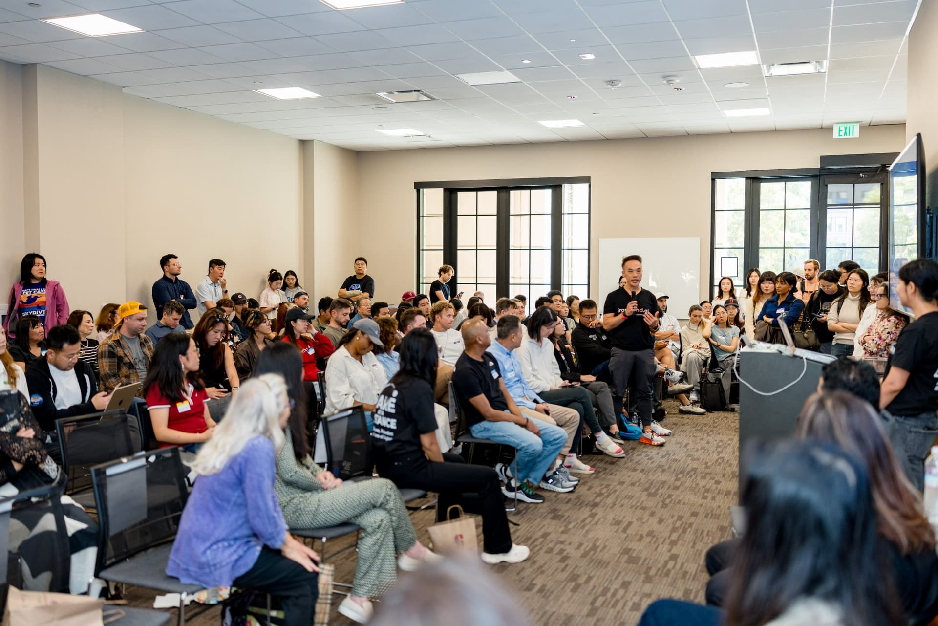 Full room seen from the back with attendees seated and standing at Care at a Distance: AI, Sensors, Robotics and the Future of Aging, SF Tech Week 2026 at EVGR, Stanford University by JY Studio