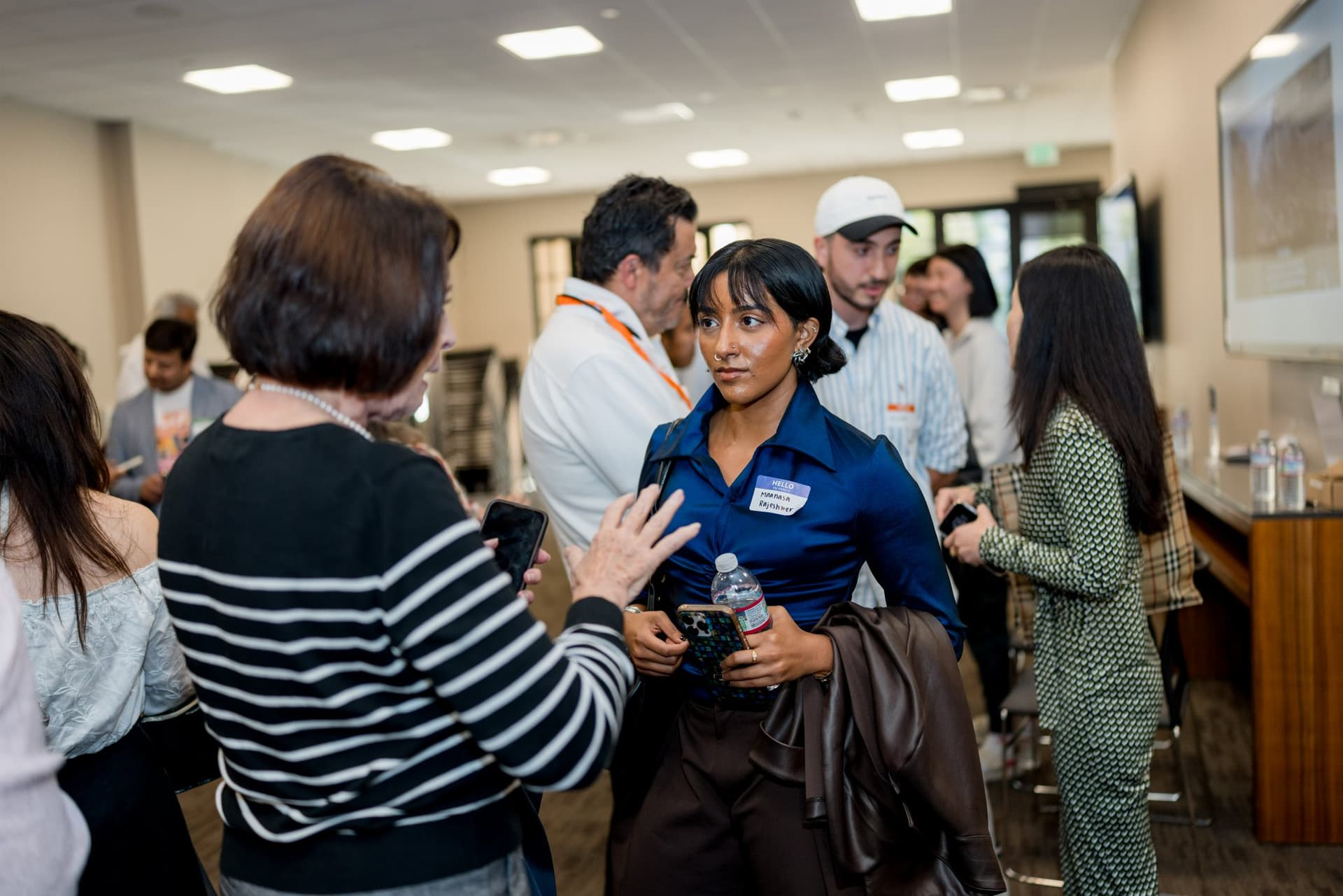 Group of attendees talking during post-panel networking at Care at a Distance: AI, Sensors, Robotics and the Future of Aging, SF Tech Week 2026 at EVGR, Stanford University by JY Studio