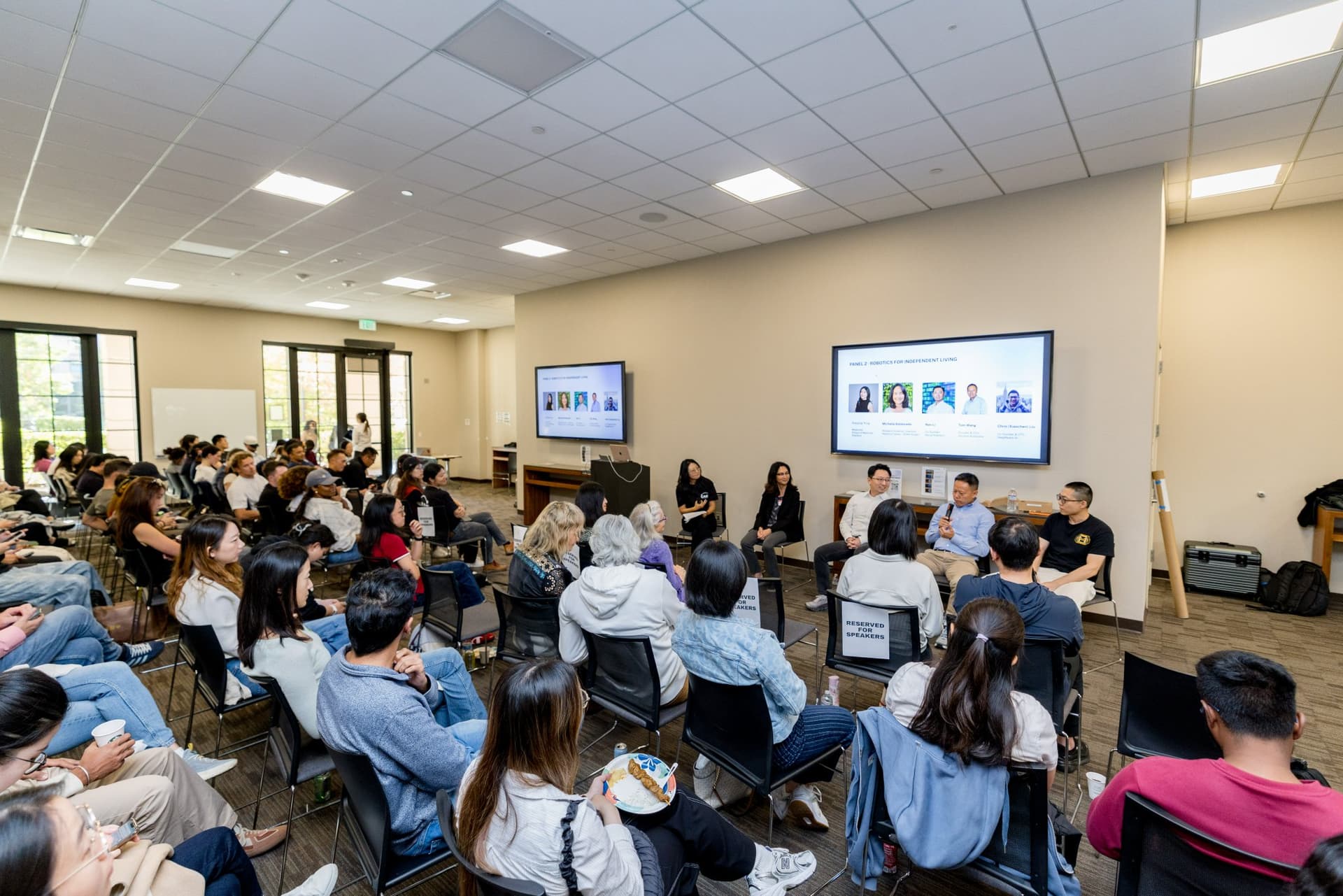 Wide shot of the packed room during Panel 2 "Robotics for Independent Living" at Care at a Distance: AI, Sensors, Robotics and the Future of Aging, SF Tech Week 2026 at EVGR, Stanford University by JY Studio