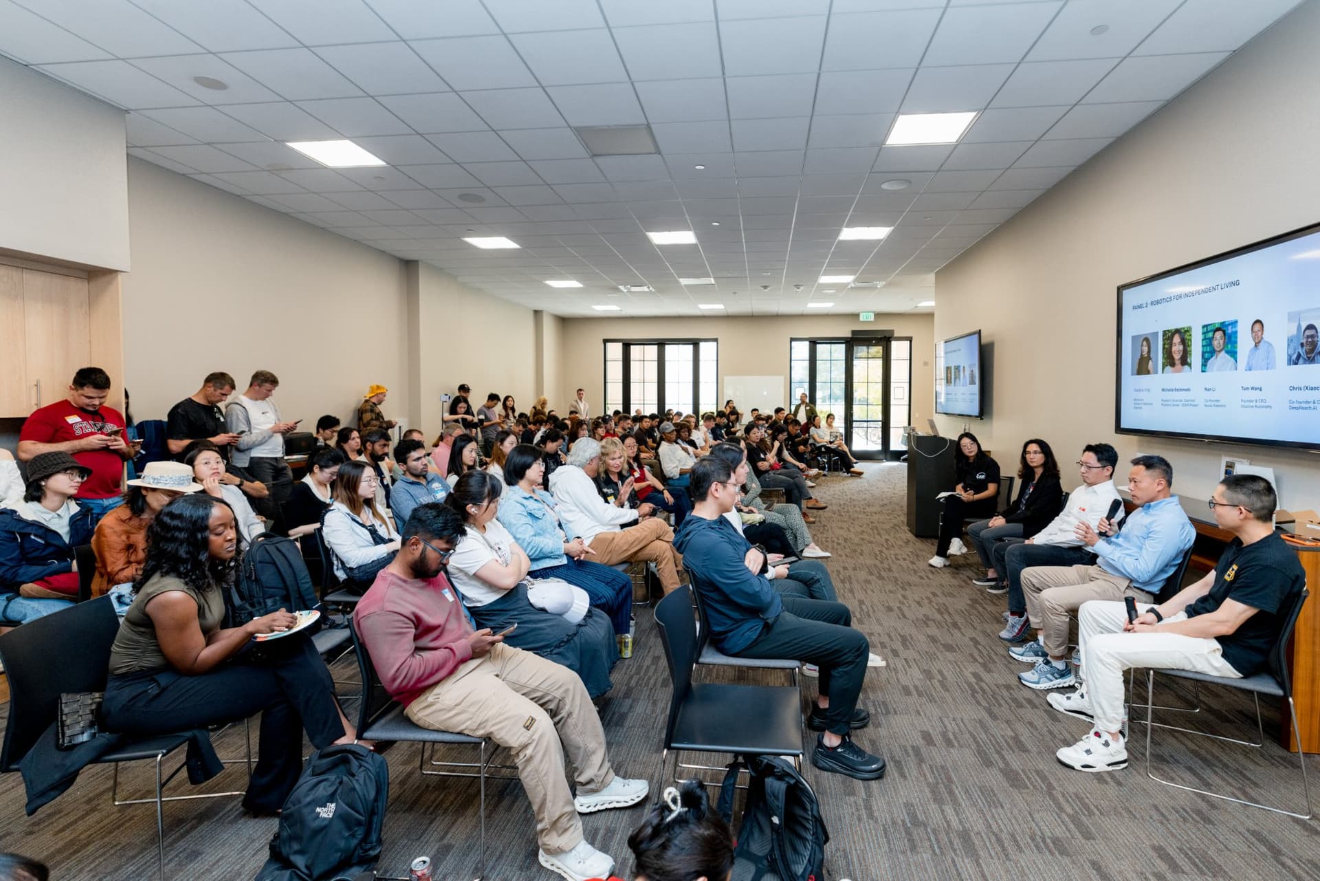 Full audience facing the Panel 2 "Robotics for Independent Living" panelists at Care at a Distance: AI, Sensors, Robotics and the Future of Aging, SF Tech Week 2026 at EVGR, Stanford University by JY Studio