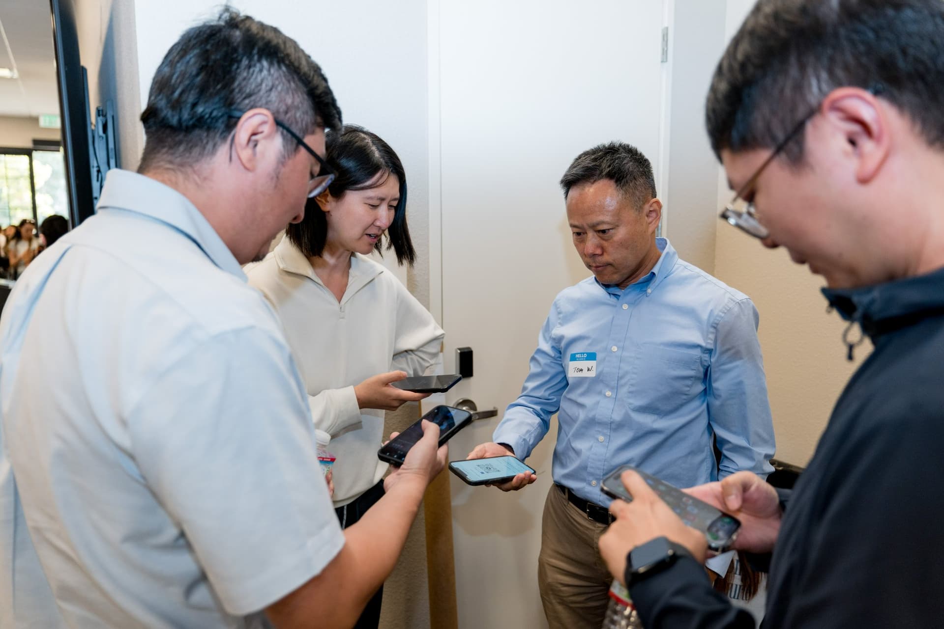 Panelist and attendees exchanging contacts on their phones after the panel at Care at a Distance: AI, Sensors, Robotics and the Future of Aging, SF Tech Week 2026 at EVGR, Stanford University by JY Studio