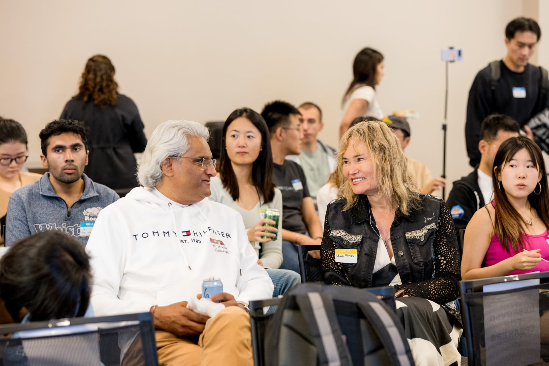 Attendees smiling and talking in their seats at Care at a Distance: AI, Sensors, Robotics and the Future of Aging, SF Tech Week 2026 at EVGR, Stanford University by JY Studio