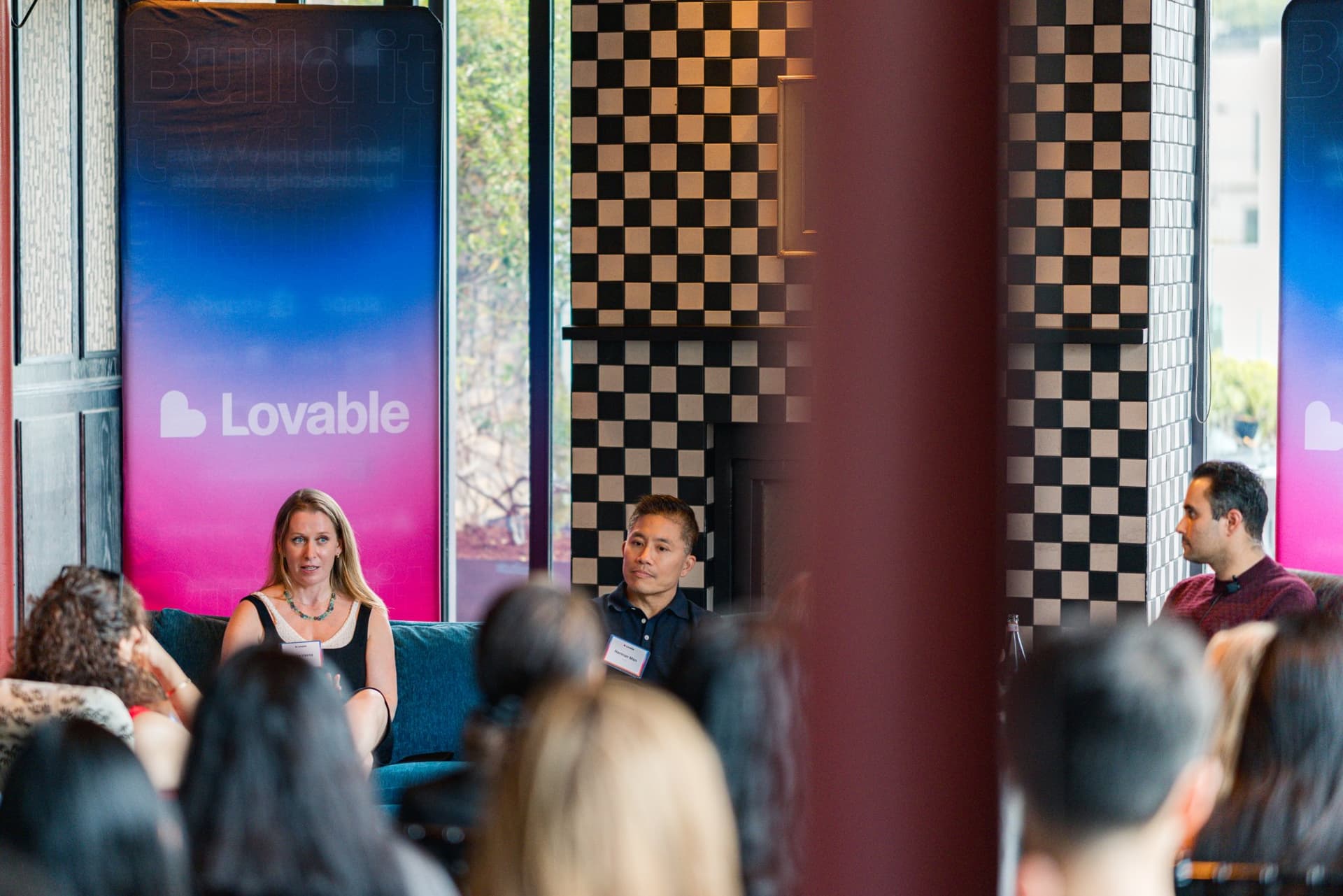 Elena Verna and Herman Man on stage seen over the heads of the audience at Lovable's When Everyone Can Build panel in San Francisco by JY Studio