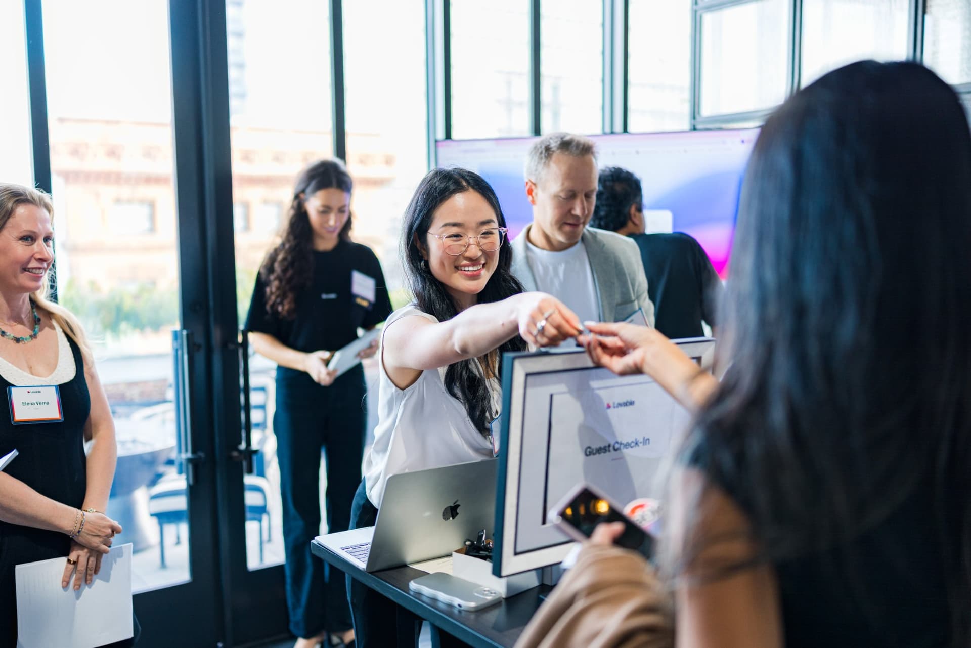 Guests receiving name badges at the Lovable check-in desk at Lovable's When Everyone Can Build panel in San Francisco by JY Studio