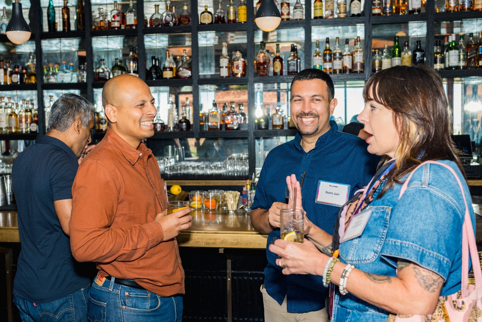 Three guests laughing together at the bar at Lovable's When Everyone Can Build panel in San Francisco by JY Studio