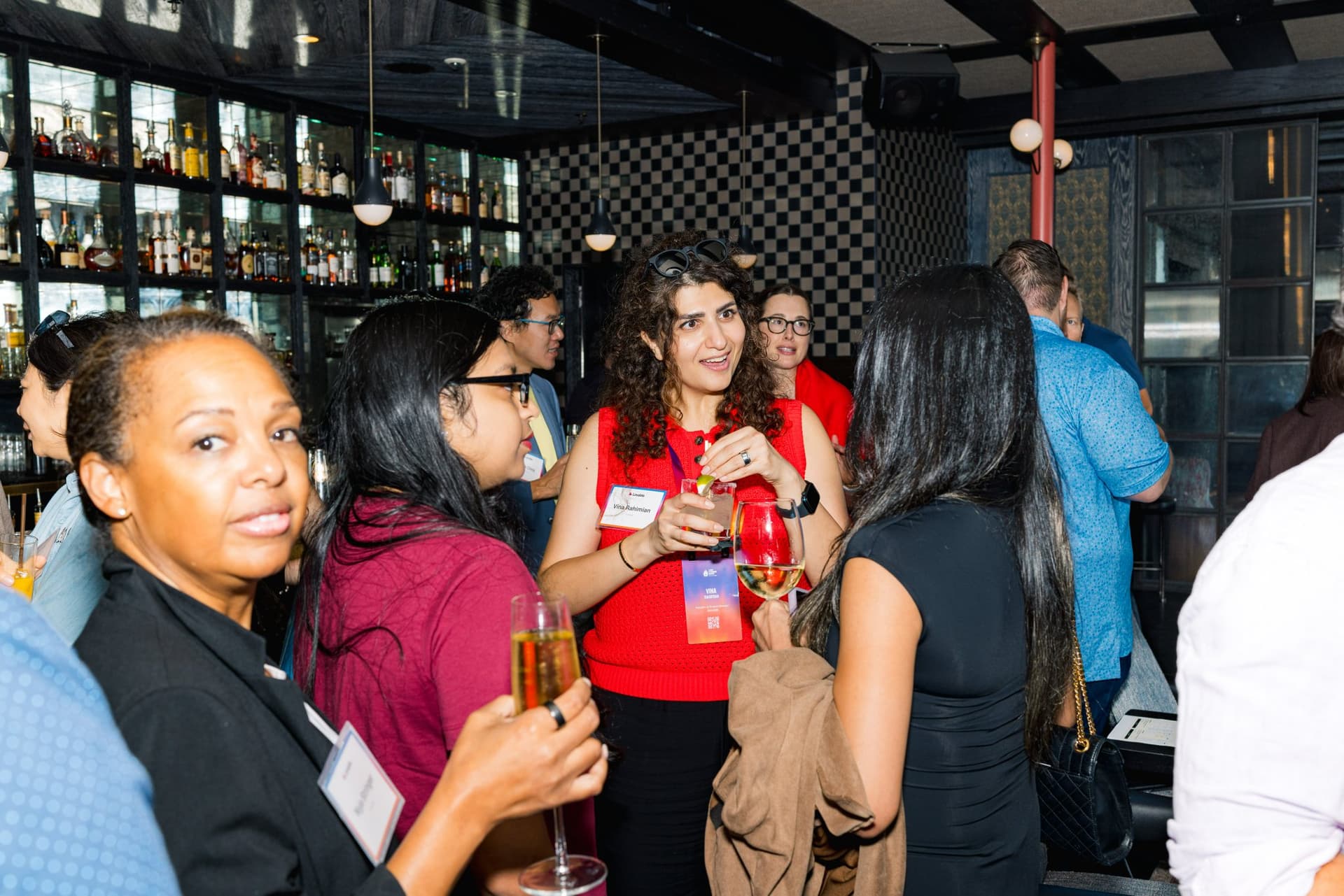 Guests chatting with drinks in hand during the networking reception at Lovable's When Everyone Can Build panel in San Francisco by JY Studio
