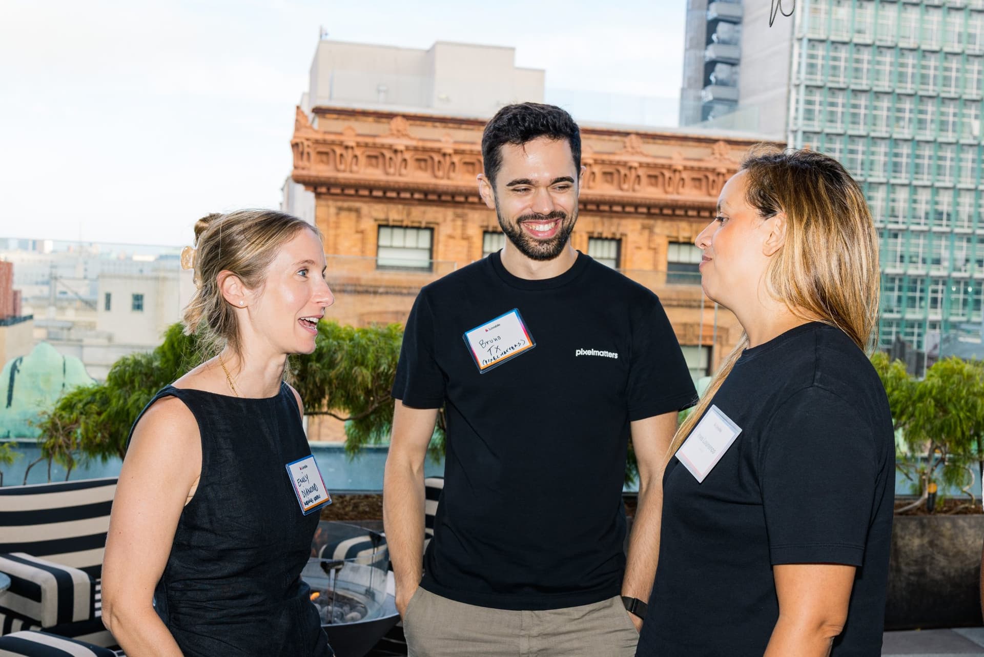 Three guests laughing together on the rooftop terrace at Lovable's When Everyone Can Build panel in San Francisco by JY Studio