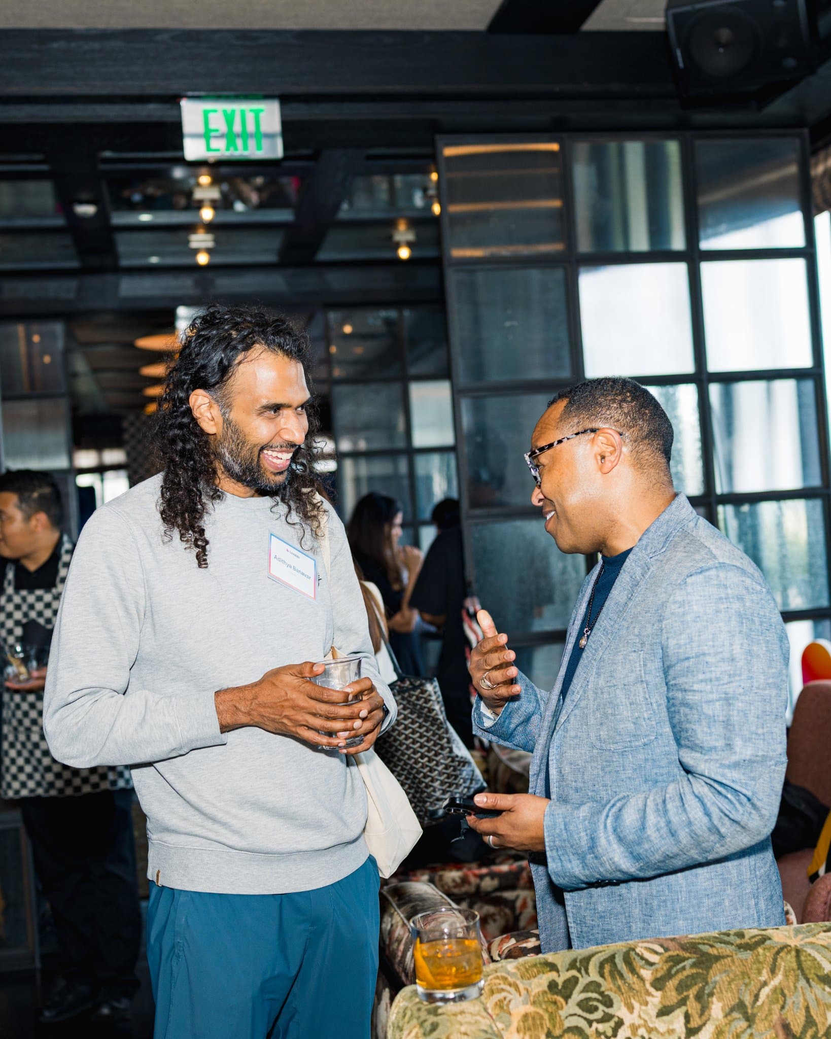 Two guests chatting over drinks during the reception at Lovable's When Everyone Can Build panel in San Francisco by JY Studio