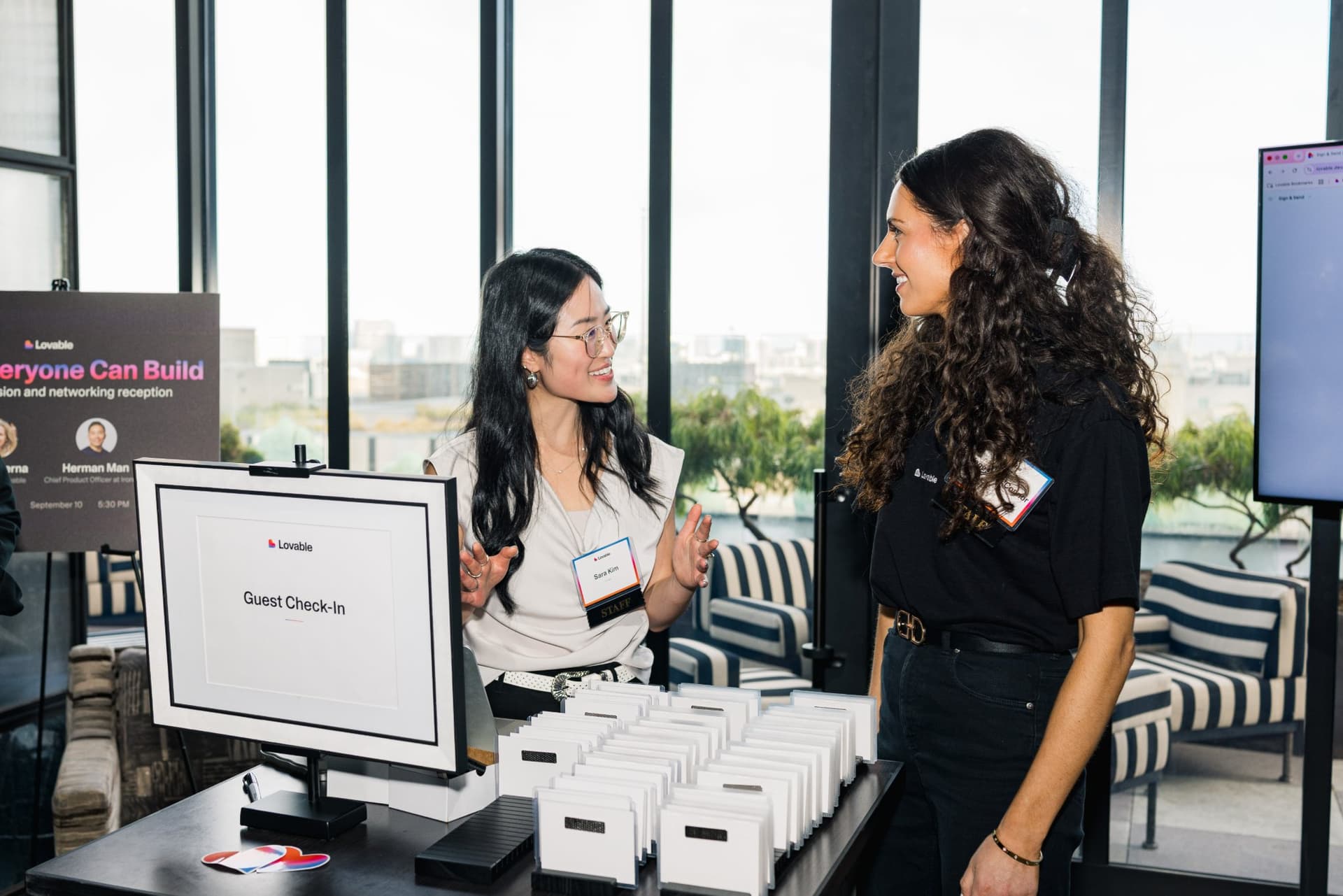 Lovable team members chatting at the guest check-in table at Lovable's When Everyone Can Build panel in San Francisco by JY Studio