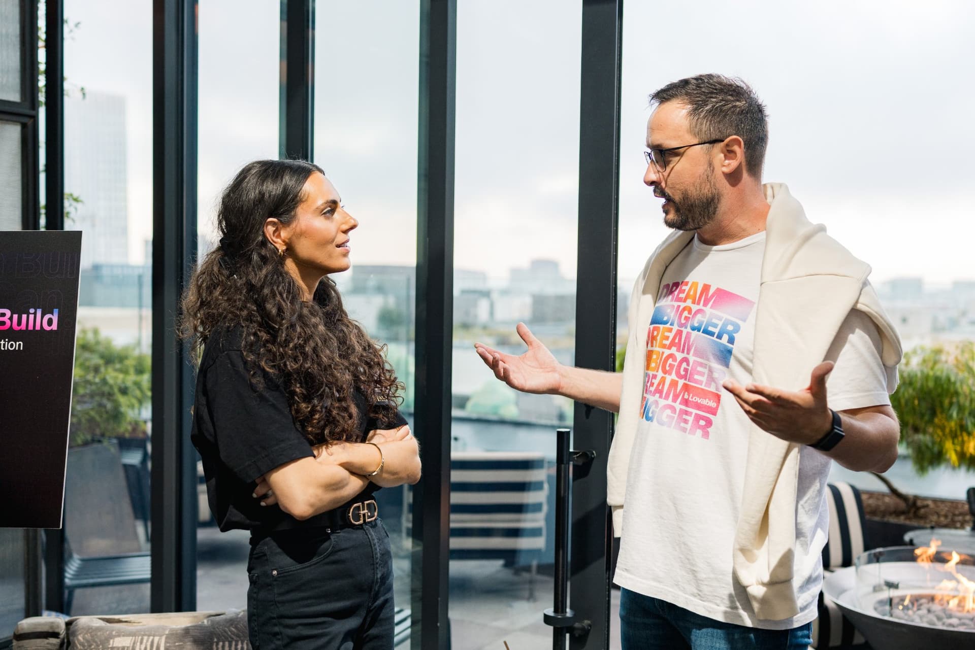 Guest in a Lovable Dream Bigger t-shirt talking with an attendee by the terrace at Lovable's When Everyone Can Build panel in San Francisco by JY Studio