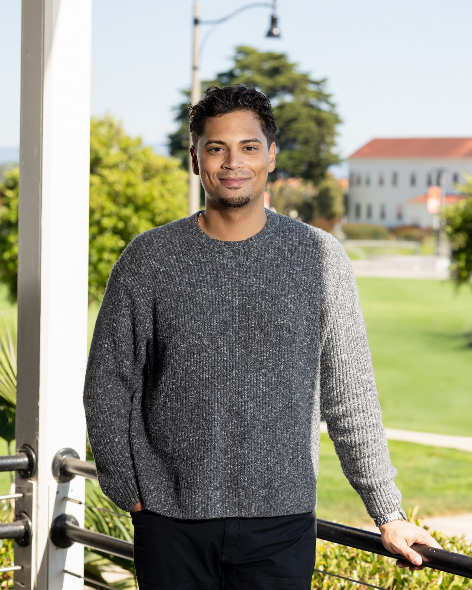General Compute engineer relaxed outdoor natural-light headshot in a grey knit sweater with green lawn and historic buildings behind, on-site corporate headshot session in San Francisco for LinkedIn and team page by JY Studio